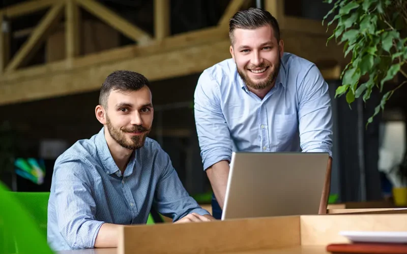 imagem-do-empresario-bonito-ouvindo-seu-colega-ou-parceiro-sobre-o-sistema-de-negocios-ner-enquanto-trabalhava-no-computador-portatil-no-interior-do-escritorio